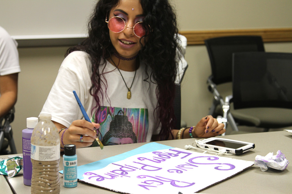 Film major Romany Manriquez works on an anti-LNG poster during the Environmental Awareness Club meeting last Thursday in Edinburg./Sarah Carvajal/The Rider