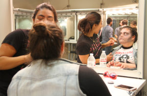 A picture of a girl getting zombie makeup