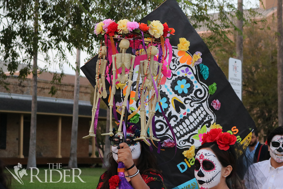 A colorful Día de los Muertos poster and plastic skeletons were among the items carried in the parade.