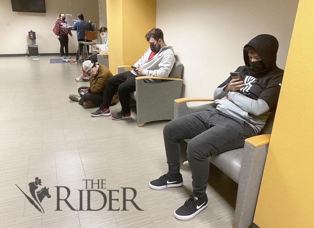 Criminal justice senior Gustavo Garcia (right) and finance graduate student Light Rios sit as they wait in line last Tuesday  at U Central. This spring semester, enrollment numbers have increased from last spring amid the COVID-19 pandemic. UTRGV’s preliminary numbers, as of last Tuesday, show 24,384 are undergraduates, 5,542 are graduate students and 221 are medical students.. Aaliyah Garza/The Rider