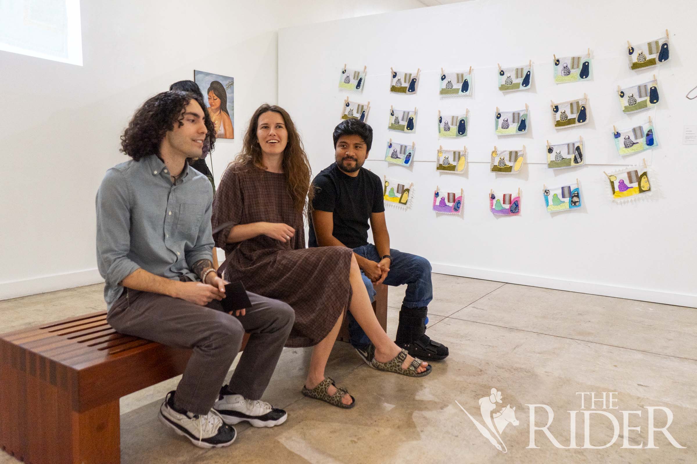 Artist and Flower Shop Art Studio founder Jesus Treviño (left) sits with Austin residents Tova Katzman and Daniel Molina during the opening reception of “Brick by Brick.” Eduardo Escamilla/THE RIDER