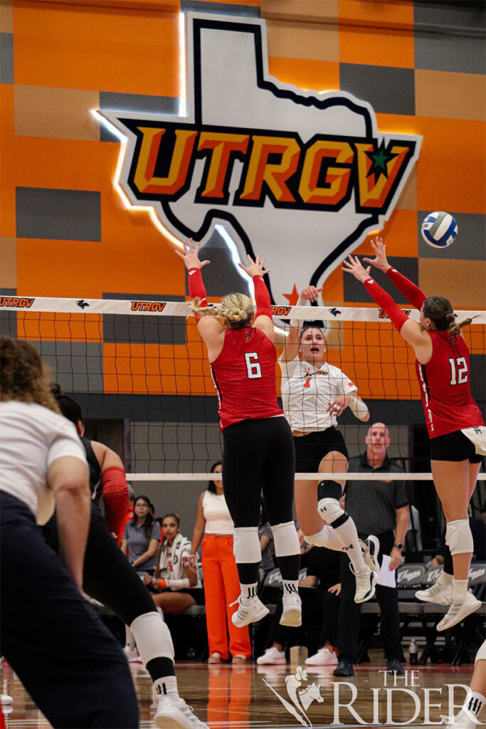 Vaqueros senior outside hitter Claudia Lupescu hits past Raiders graduate student middle blocker and right-side hitter Reagan Leinen (left) and junior setter Hanna Borer during tonight’s game in the UTRGV Fieldhouse on the Edinburg campus. The first home game of the season drew 2,771 attendees. Abigail Ollave/THE RIDER