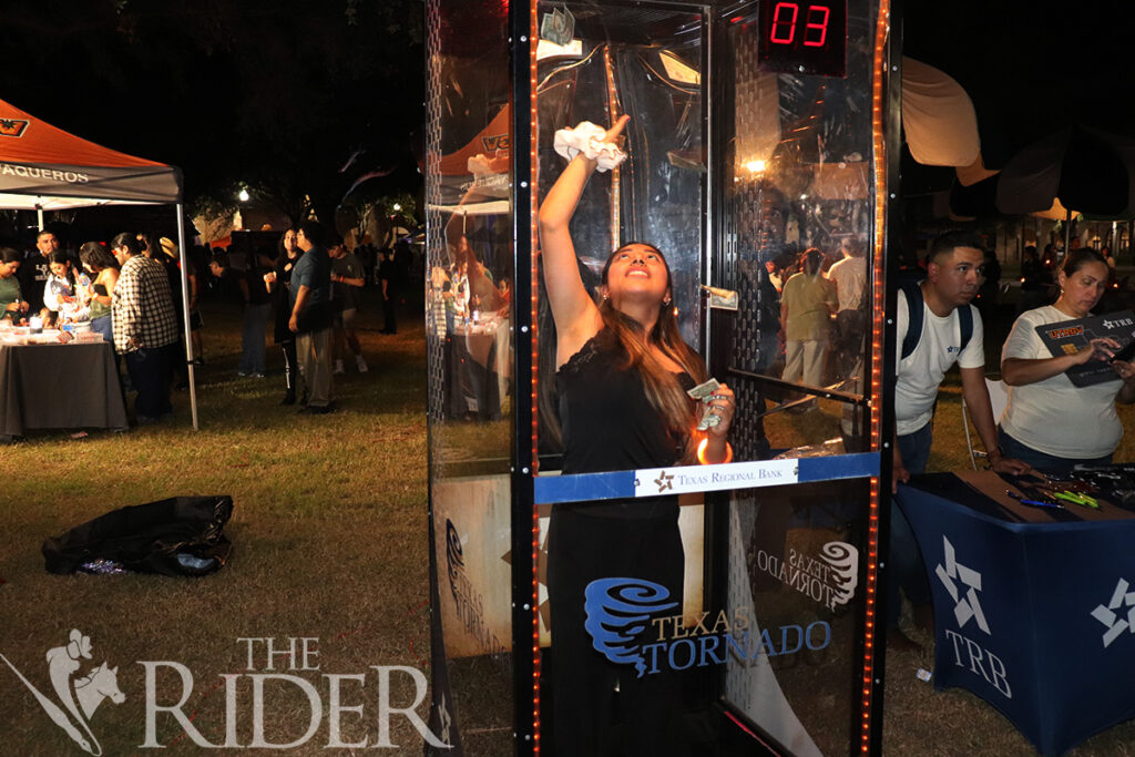 Damaris Marroquin, an early care and early childhood studies junior, catches dollar bills at Texas Regional Bank’s money booth Aug.27 at The Stomp on the Student Union lawn on the Brownsville campus. Texas Regional Bank was among several businesses that participated in the event’s Business Showcase. Silvana Villarreal/THE RIDER