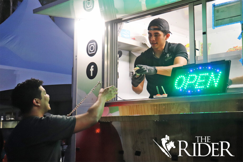 Michael Martinez, manager for La Garrafa Nieve Artesanal, serves ice cream to nursing junior Derian Hernandez during The Stomp Thursday in Lot E-8 on the Edinburg campus. Angel Ballesteros/THE RIDER