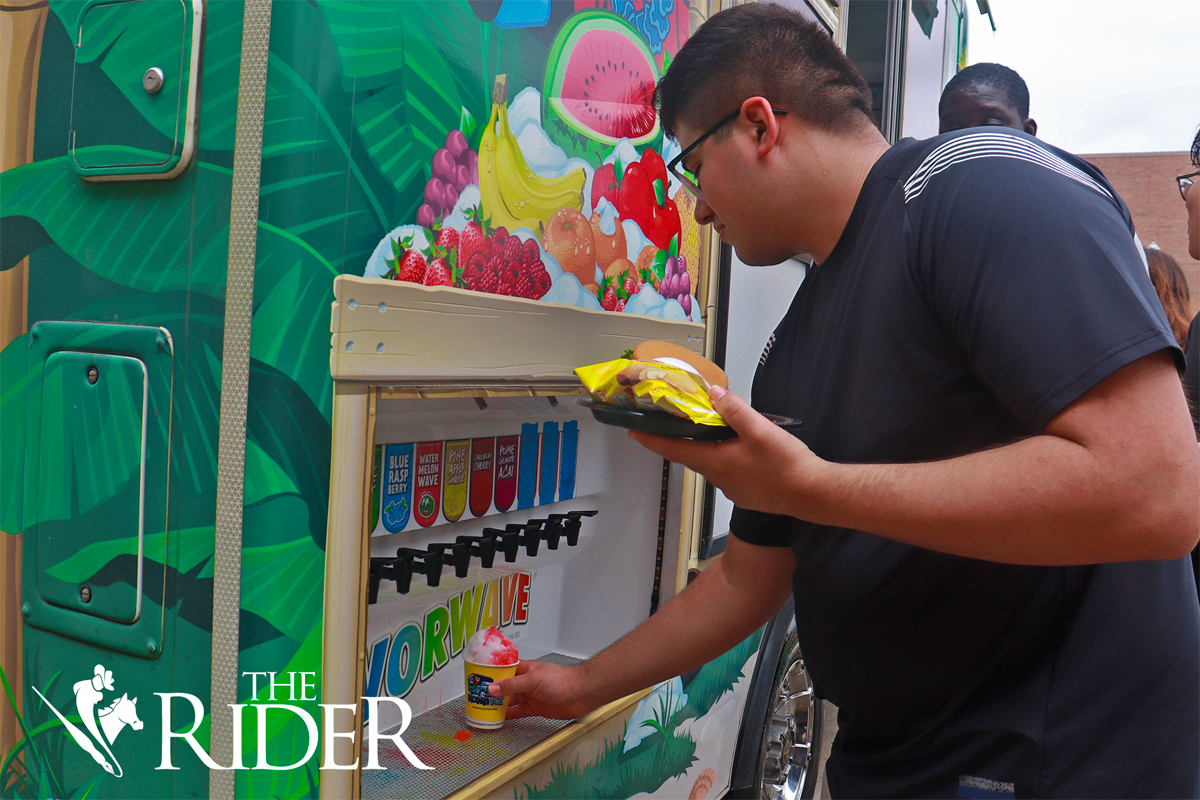 Biomedical science freshman Chris Rivas adds syrup to his Kona Ice cone during Picnic with the President Wednesday afternoon in the University Ballroom on the Edinburg campus. Angel Ballesteros/THE RIDER