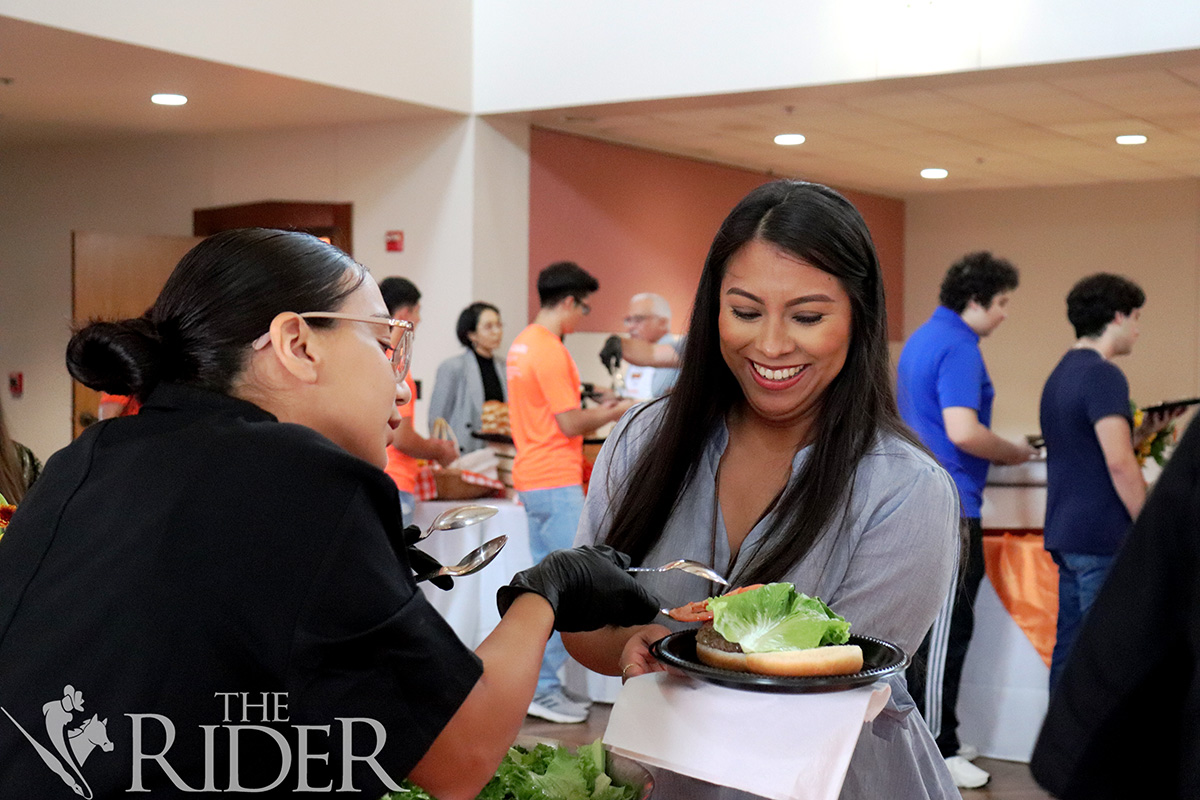 Francis Galvan, accountant for the UTRGV Division of Research, picks up toppings Thursday during Picnic with the President in the PlainsCapital Bank El Gran Salón on the Brownsville campus. Venisha Colón/ THE RIDER