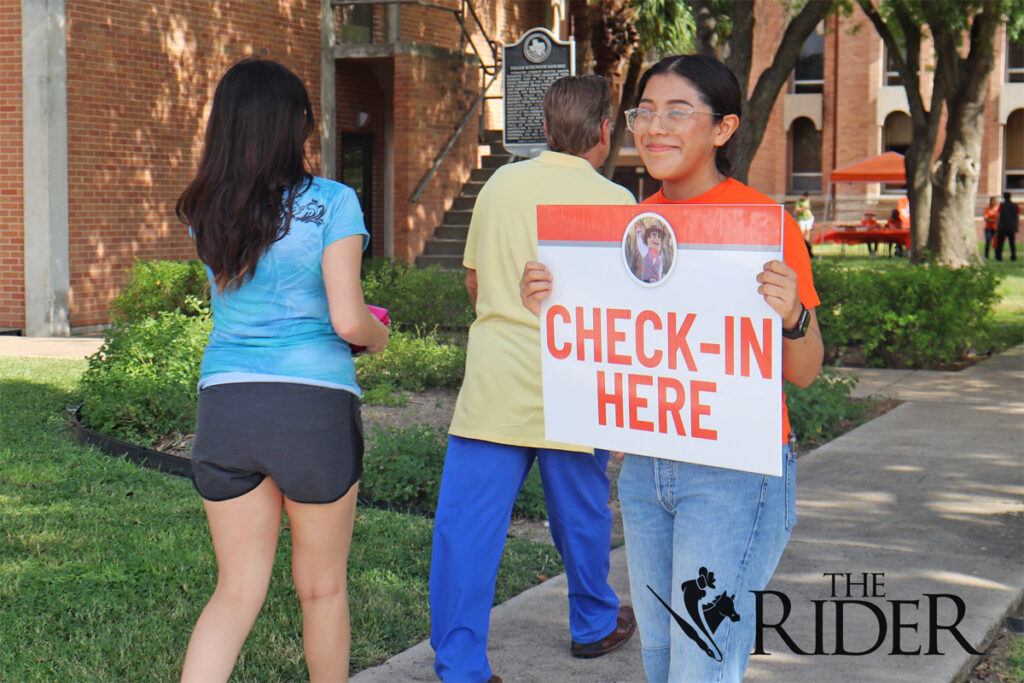 Laura Reyes, chair of the senate for the Student Government Association, guides students and parents to Heritage Hall Aug. 23 on the Edinburg campus. Angel Ballesteros/THE RIDER