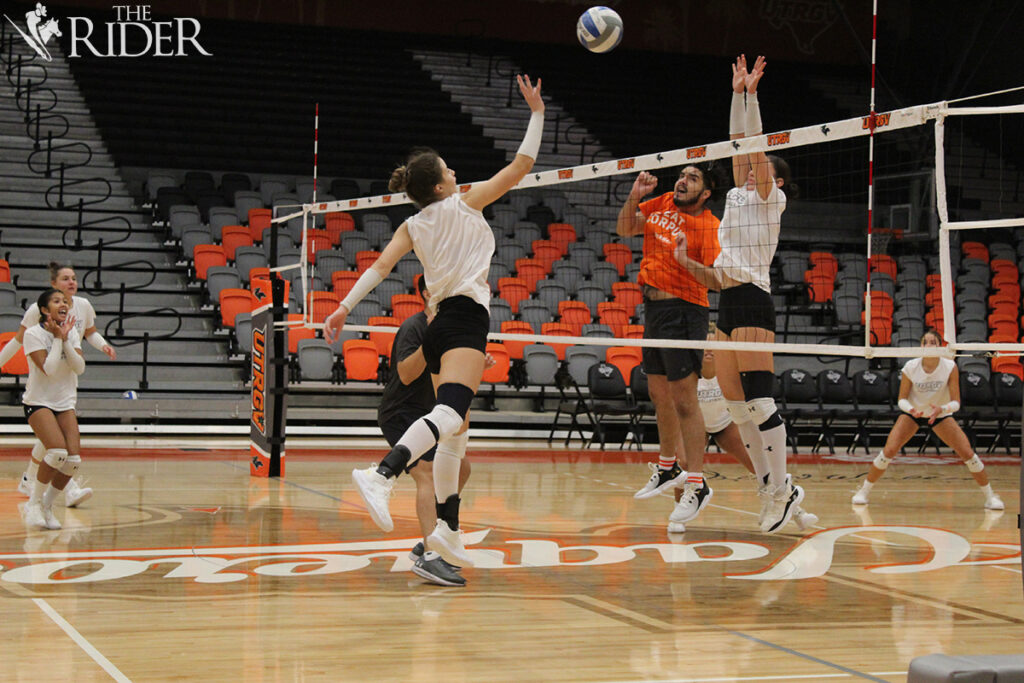 Sophomore outside hitter Giovana Ribeiro tips the ball over sophomore middle blocker Julianna Bryant and volunteer assistant coach AJ Sanchez during practice Wednesday in the UTRGV Fieldhouse on the Edinburg campus. Raquel Cazares/THE RIDER