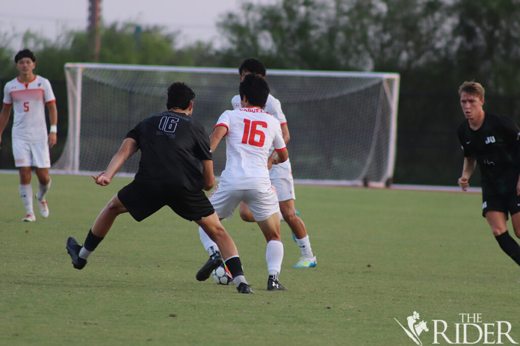 Vaqueros senior forward Sora Noda tries to defend the ball against Dolphins junior defender Orion McHugh (16) Thursday at the UTRGV Soccer and Track & Field Complex on the Edinburg campus. The Vaqueros drew the match 1-1. Raquel Cazares/THE RIDER