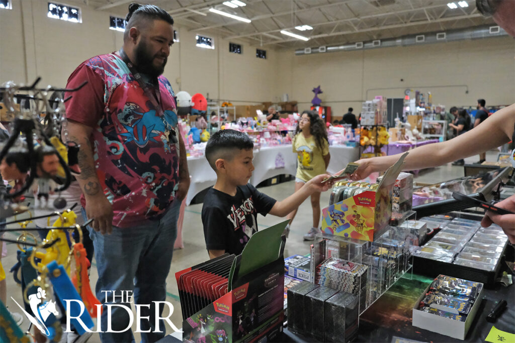 Mission resident Yahir Limon purchases a pack of Pokémon cards from the CY Cards and Collectables booth during the RGV PokéFest Sept. 21 in the Mission Parks and Recreation building. Also pictured is Mission resident Leo Salinas. Angel Ballesteros/THE RIDER