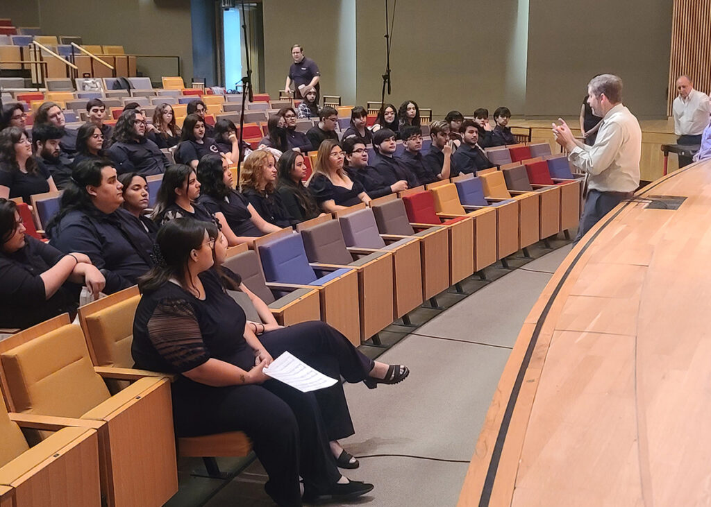 UTRGV Master Chorale and University Choir students listen to Jeffrey Ward, dean of the College of Fine Arts, speak last May at the UTRGV Performing Arts Complex on the Edinburg campus. UTRGV film and choir students contributed to a documentary and music video that raise awareness about the global crisis of displaced children. PHOTO COURTESY UTRGV Theatre Department