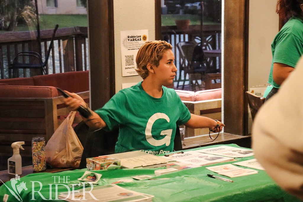 Robin Lee Vargas, Green Party candidate for Texas Senate in District 27, sets up an information table on Tuesday at Cobbleheads in Brownsville during a Green Party campaign event. Venisha Colón/THE RIDER