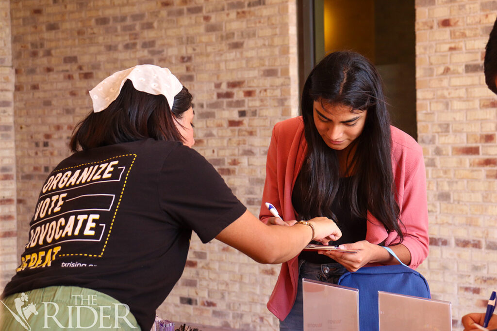 Public affairs graduate student Estrella Torres, the Texas Rising regional program coordinator, assists freshman Marelin Barrales in completing a voter registration application Oct. 7 outside the University Library on the Brownsville campus. Venisha Colón/THE RIDER