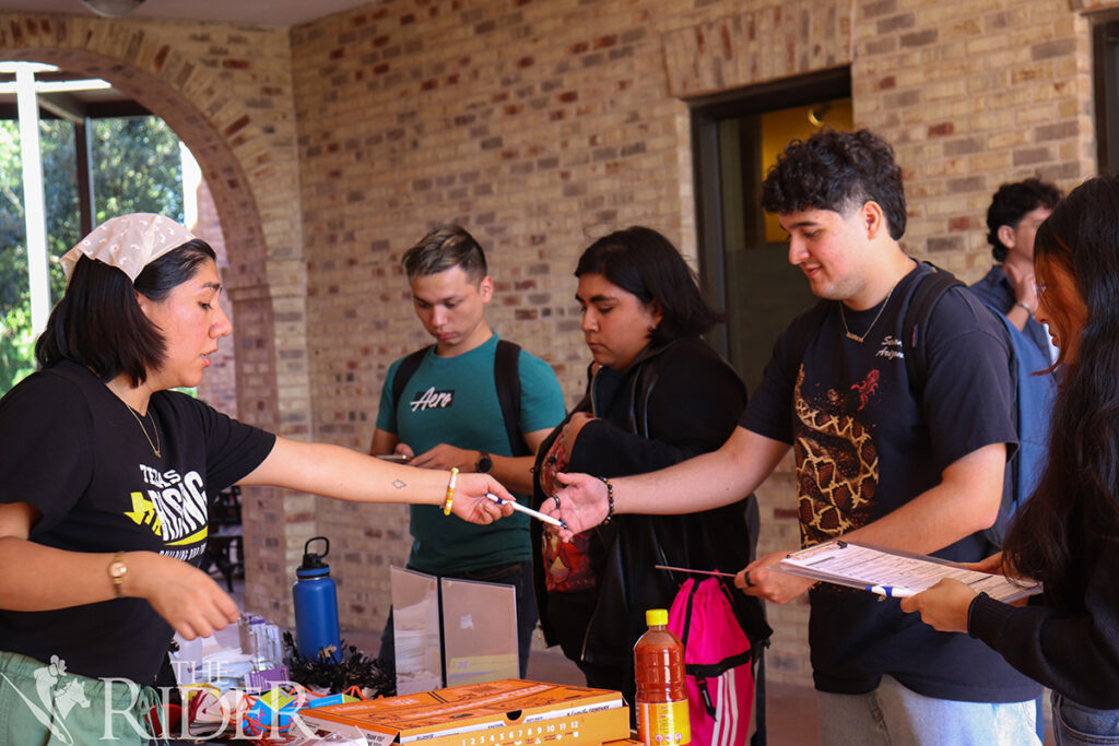 Public affairs graduate student Estrella Torres, the Texas Rising regional program coordinator (from left), helps nursing freshman David Tamez check his voter registration status Oct. 7 outside the University Library on the Brownsville campus. Also shown are management senior Gabriel Morales, visual communication design senior Christalinda Beltran and integrated health science sophomore Dulceaylin Ramirez. Venisha Colón/THE RIDER